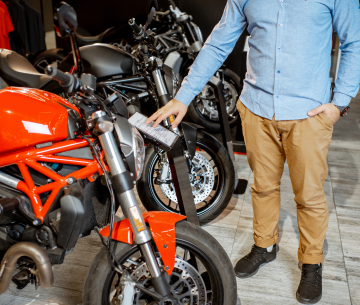 man-choosed-motorcycles-moto-shop-guy-black-jacket-man-helmet_1157-44648 Person struggling to ride a motorcycle that's too big